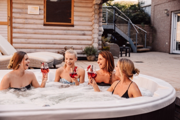 A hen party toast the bride in an outdoor hot tub