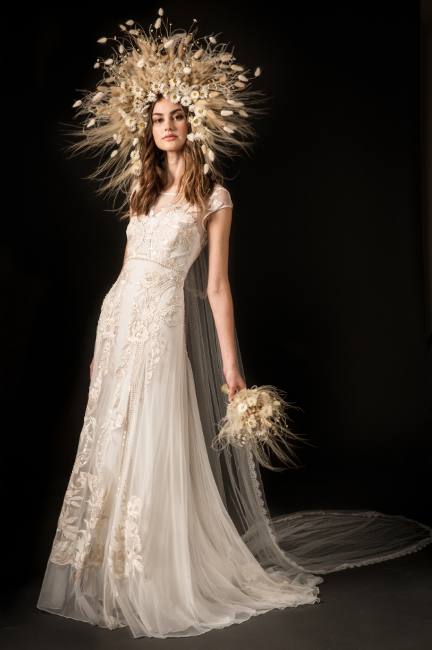 Model in a studio setting wears wedding dress with large headdress