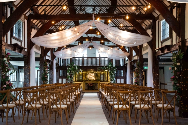Inside of wedding venue with wooden beams set up for a ceremony