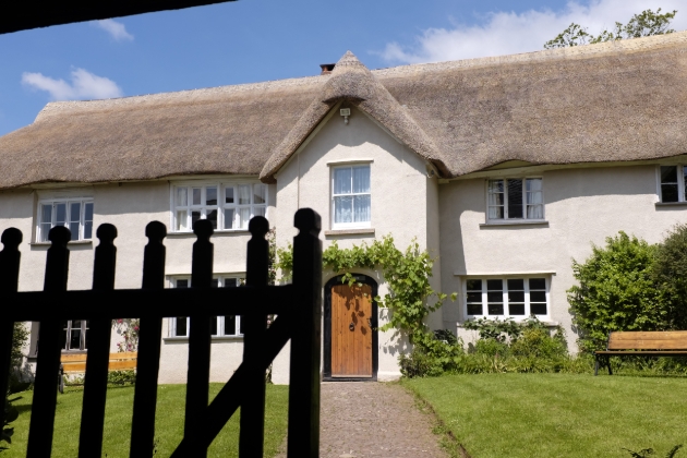 Middle Coombe Farm front of farm house with gate, bench and thatched roof