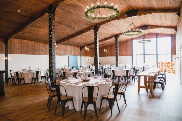 inside barn, floral hanging chandelier, wedding tables and chairs
