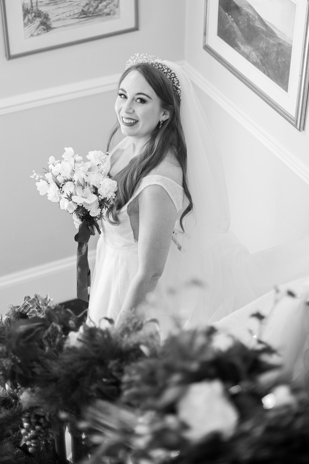 Black and white image of bride holding bouquet on the stairs