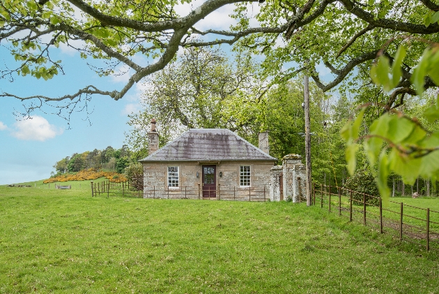 grey flint cottage in middle of a field