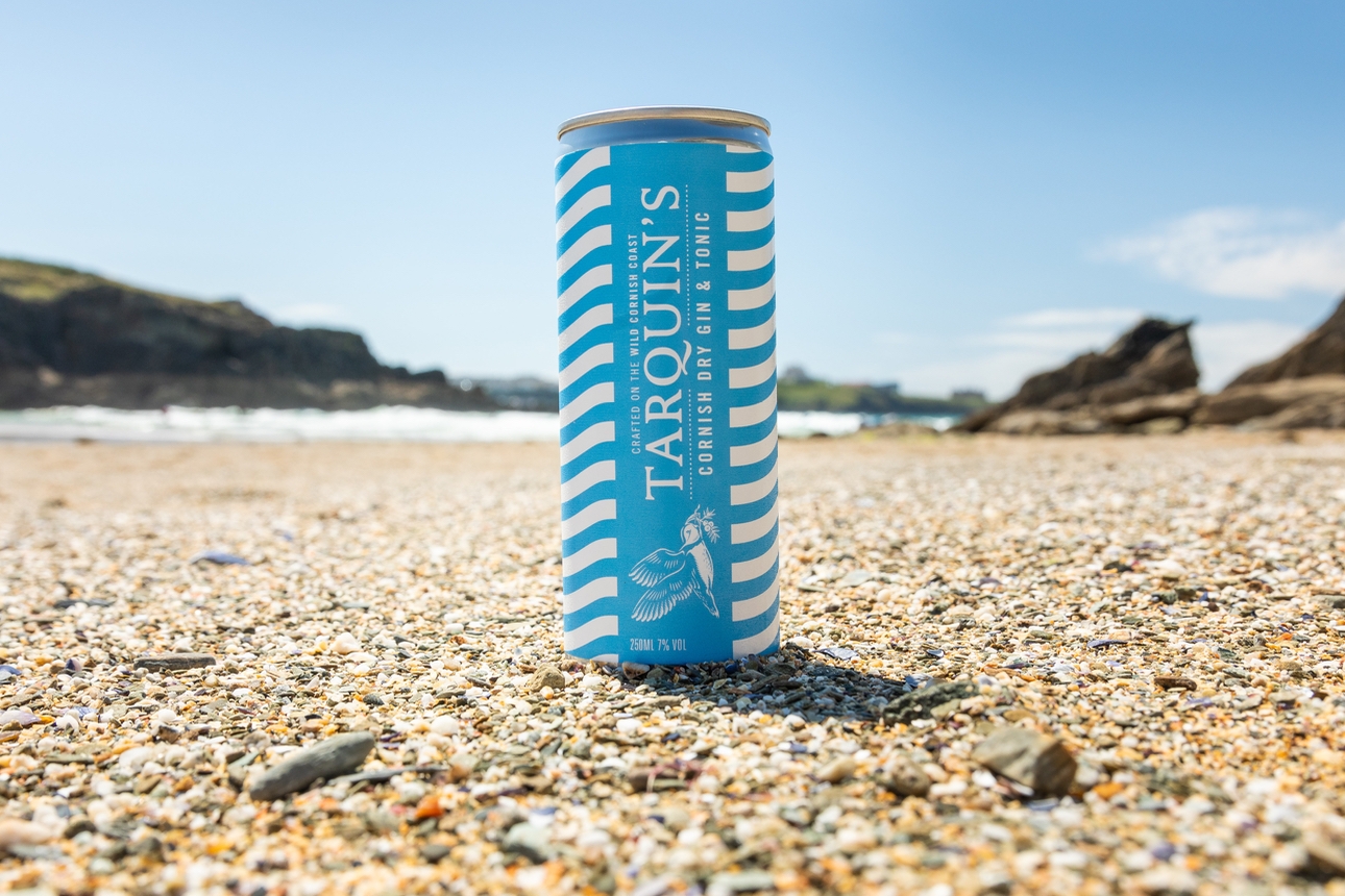 A can of Tarquin's grab-and-go gin and tonic on a beach
