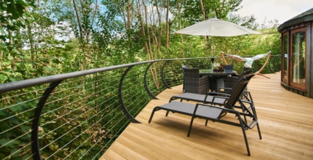 Wooden deck with sunloungers with curved black metal railings