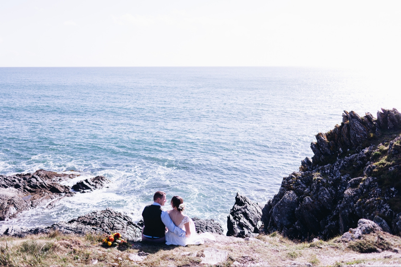 Couple sat on cliff edge