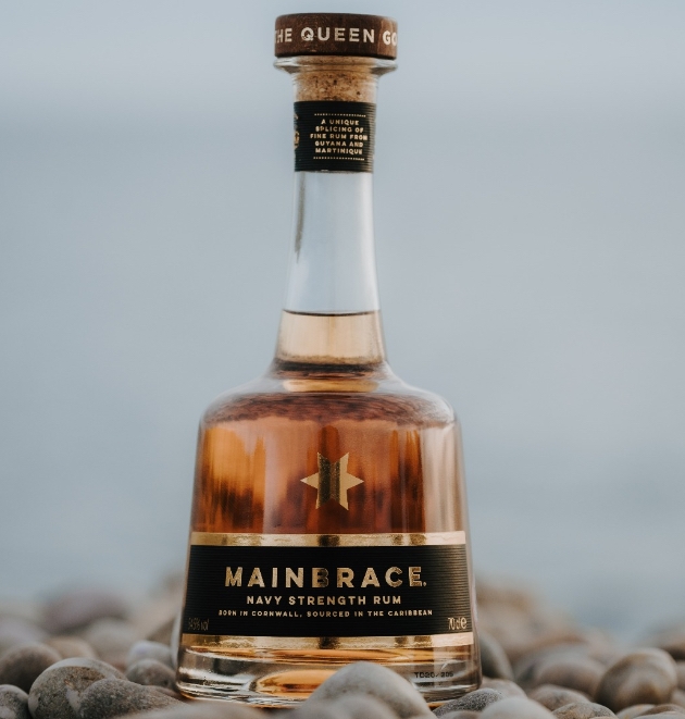 A bottle of Mainbrace Rum on a stony beach