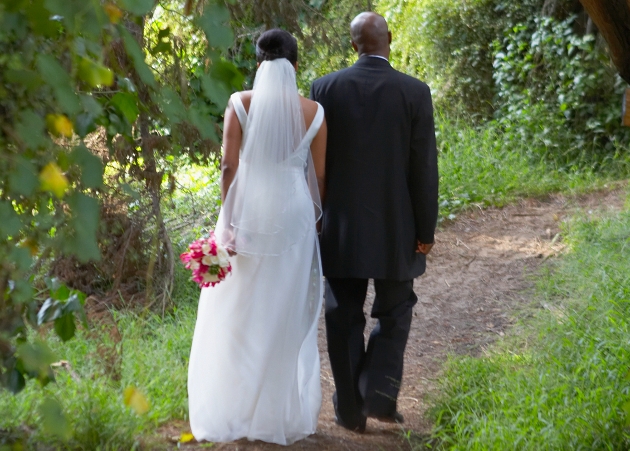 bride and groom going for a walk through gardens