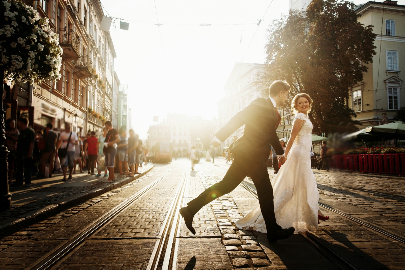 bride and groom crossing street in sun