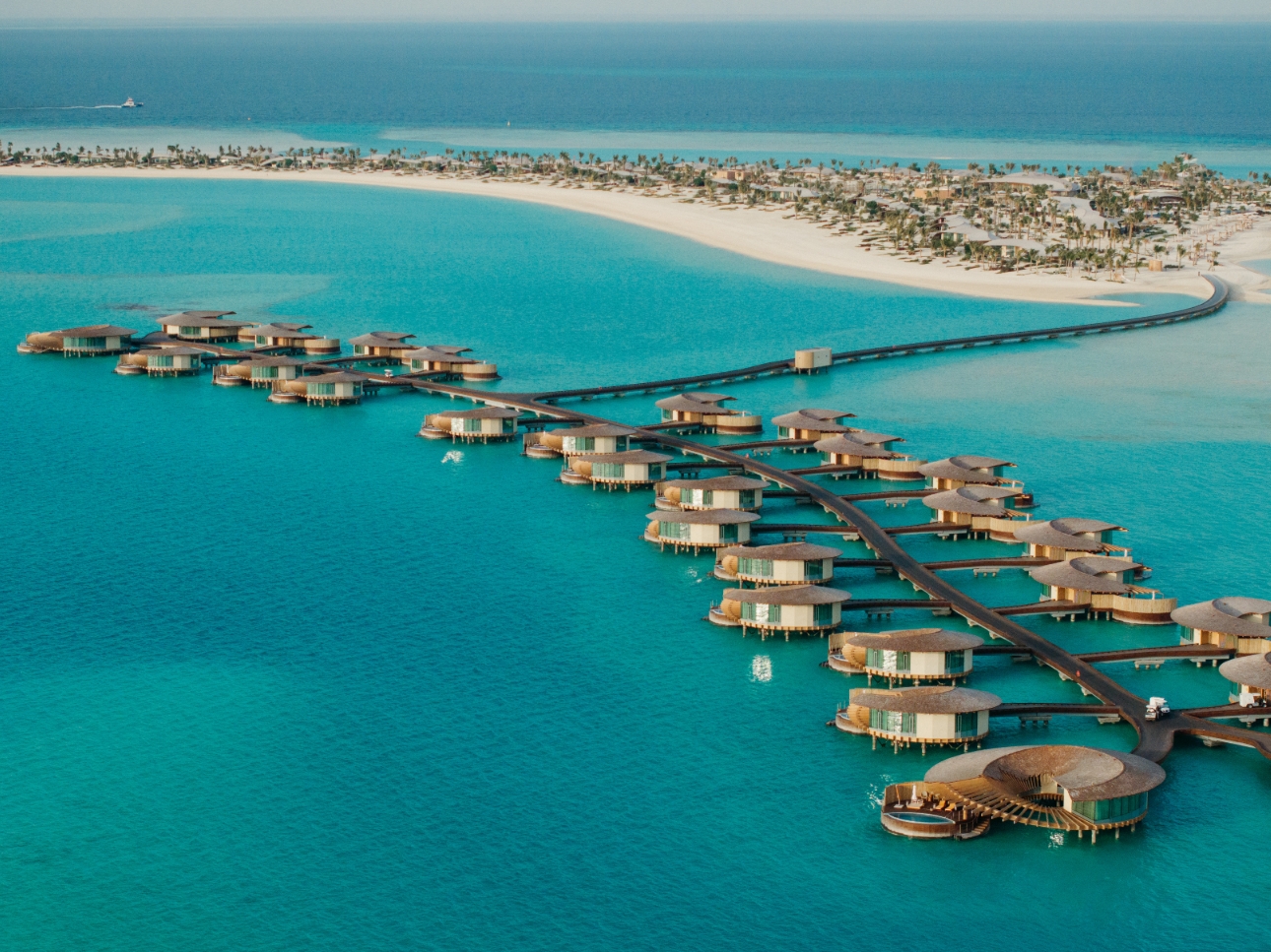 Huts over clear blue water 